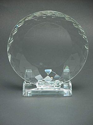 CG0415 - Optic Crystal Plate with stand.  Avail. in 3 sizes: 5 1/4 to 6 3/4 in.
Engrave on the face of the crystal.