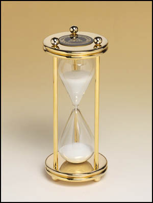 555 - Glass crystal sand timer with polished brass finish case and columns with black brass plate.